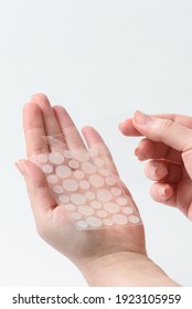 Round patches for acne and wrinkles on the hands on a white background. Acne and wrinkle patches for facial rejuvenation. Facial cleansing cosmetology.