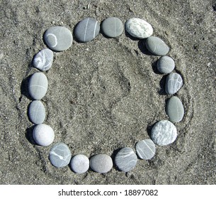round pebble frame lying on a sand
