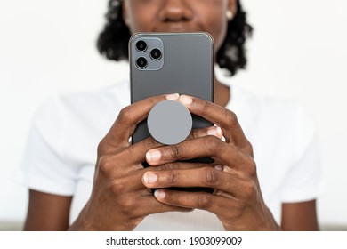 Round phone grip behind the mobile with African American woman texting on the phone - Shutterstock ID 1903099009