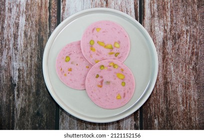 Round Pieces Of Meat Sausage With Pistachios On A Plate