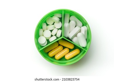 Round Pill Box With Different Pills Close-up On A White Background.