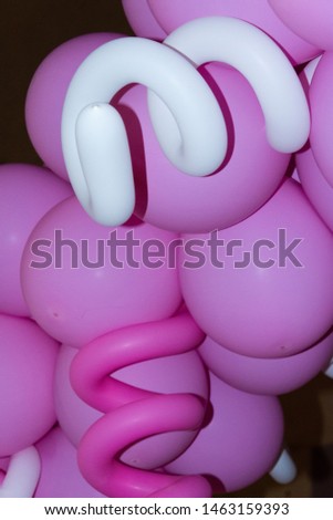round pink and spiral white inflatable balloons at a party in the evening