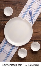 Round plate and empty round tea cups on towel