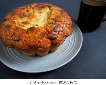 Round Pumpkin Pie Made Of Corn And Rice Flour On A Gray Plate Next To A Glass Coffee Mug On A Black Background Side View . Gluten Free Baked Goods Made At Home