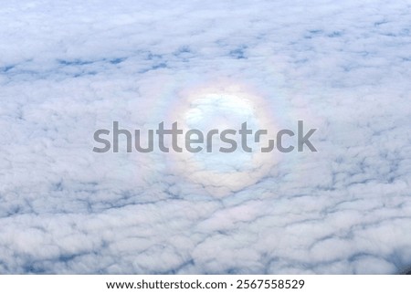 Round rainbow in the cloudy sky. View from the airplane window. 