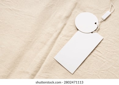 Round and rectangle shape of price tags on beige emty cloth