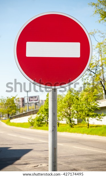 Round red road sign on metal pole. No Entry\
road-sign mounted on urban\
roadside