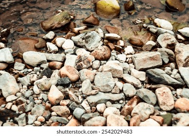 Round river pebbles scattered along the shoreline. Smooth, rounded pebbles by the riverbank
 - Powered by Shutterstock