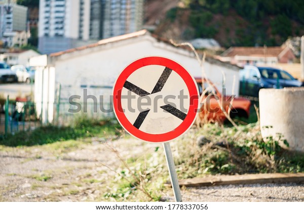 A round road sign with a Black Cross\
on the white background sign means a parking\
ban.
