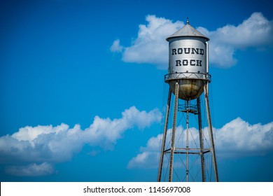 Round Rock , Texas Historic Old Water Tower. Blue Sky And Summer Heat With Metal Silver Water Tower Standing Tall In Town Square