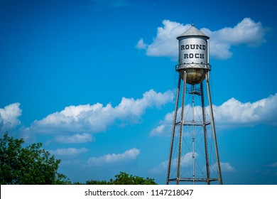 Round Rock , Texas Historic Old Water Tower. Blue Sky And Summer Heat With Metal Silver Water Tower Standing Tall In Town Square