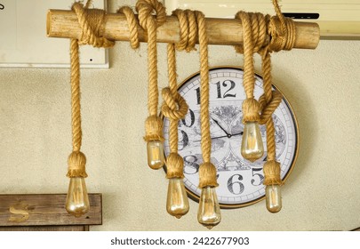 Round shape clock wall, background. Framed by lightbulbs hanging on the rope.