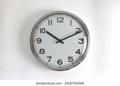 A round shape stainless steel wall clock with white face and hands set to 10:10 o'clock time. The clock is hanging on a wall.