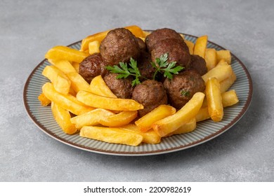 Round shaped balls of dry meatballs and french fries. Turkish name; kuru kofte ve patates