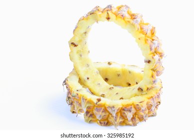 round shell of pineapple with slices isolated on white background