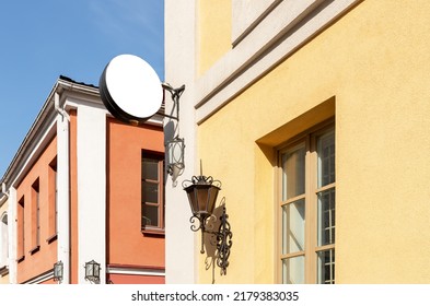 Round Signboard Mockup At Old City Building With Retro Lantern. White Template For Displaying Cafe, Restaurant, Shop, Museum, Hotel Name Or Logo. High Quality Photo