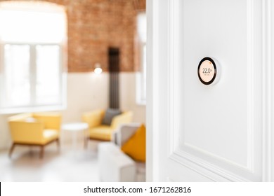 Round Smart Thermostat With Touch Screen Installed On The Wall Indoors. Smart Home Heating Regulation Concept