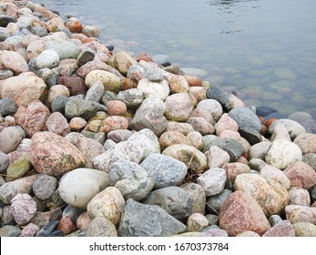 Round and smooth cost stones near water surface
