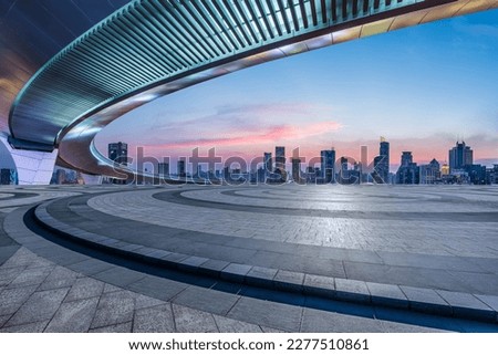 Round square floor and bridge with city skyline at sunset in Shanghai, China.