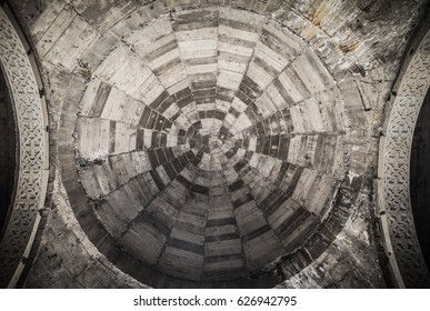 Round stone pattern on a ceillar of ancient church. Toned.