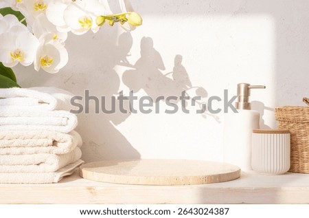 Round stone podium with empty space, set of spa bathing tools and orchid flowers on abstract texture plaster wall background in sunlight shadows. NO AI USED