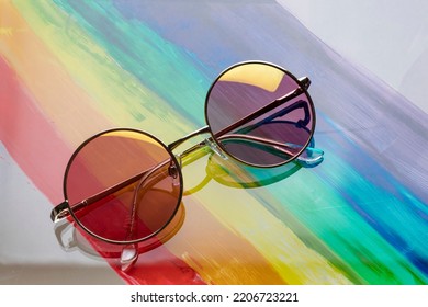 Round sunglasses and pink glasses and gradient in metal frame rainbow background  Sun glare the glass  The concept new look at the LGBT community 