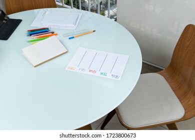 Round table with work objects during home office - papers, book, pens, tablet (translation: Mon, Tue, Wed, Thu, Fri).