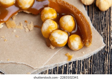 round tartlet with salted caramel and roasted hazelnuts, a delicious dessert of shortbread cookies with nuts and soft caramel - Shutterstock ID 2283102341