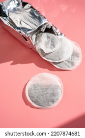 Round Tea Bag On Pink Background, Sun Shadows.