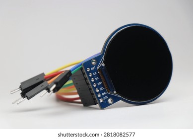 Round TFT LCD screen connected with jumper cables used in electronic projects
