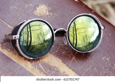 Round Vintage Glasses With Mirror Glass. Reflection Of Forest And Sky.
