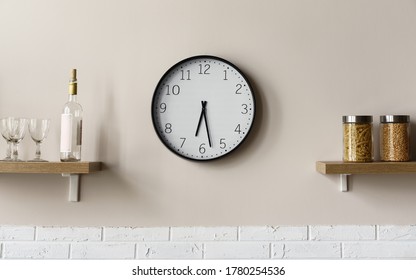 Round wall clock between wooden kitchen shelves - Powered by Shutterstock