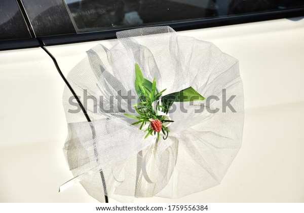 round white bow with a flower in the center,
wedding car decoration