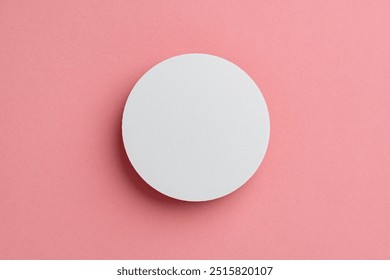 Round White Object Centered on Soft Pink Background