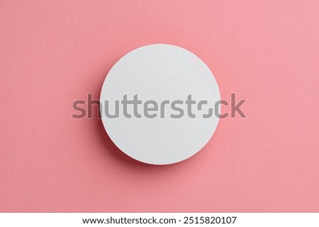 Round White Object Centered on Soft Pink Background
