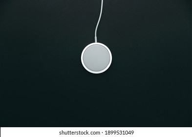 Round White Wireless Charging With Magnet On A Dark Gray Background. Modern Technology, Portable Charger, Fast.