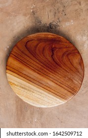 Round Wooden Cutting Board On Beige Rustic Kitchen Table. Space For Your Recipe Or Menu. Top View.