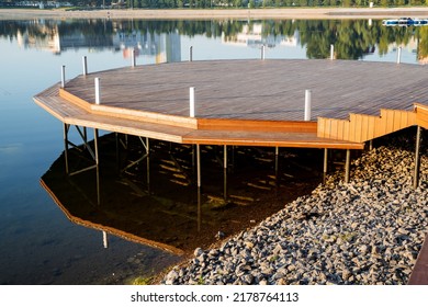 Round Wooden Pier On The River Bank, A Place For A Boat Mooring, A Pedestal Of Boards, A Platform For Morning Meditation, A City Park In The Morning There Are No People. High Quality Photo