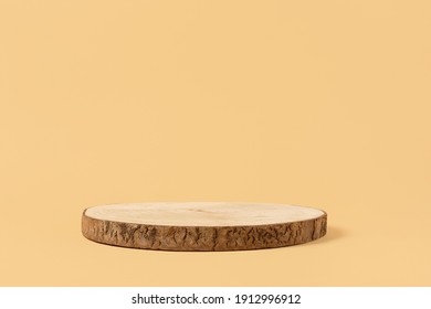 Round wooden saw cut cylinder shape for product presentation on a beige background. Round geometric shape of the cylinder. wood slice