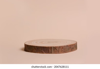 Round wooden shape of a saw cut tree on a beige background. Empty stage showcase for your product presentation.?opy space for text.