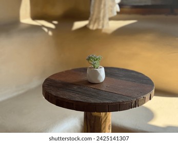 Round wooden table with white pots, minimalist.