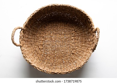 Round Woven Basket With Two Handles On White Background.