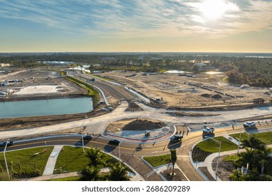 Roundabout intersection construction in North Port, Florida. Development of American road circle with moving traffic cars. Urban circular transportation crossroads