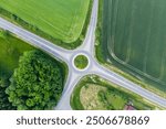 The roundabout road aerial view that newly developed. Summer sunny day. Roundabout on suburban road. Universal road photo. Road in agricultural fields landscape adn small town.