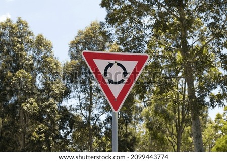 Roundabout sign with trees in background
