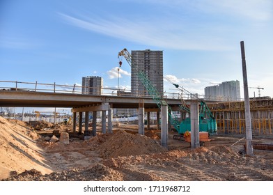 Roundabout and traffic bridge construction. Construction highway ramps and bridgeworks. Crane for formwork on bridge project works. Road work on traffic highway, road intersection junction and freeway