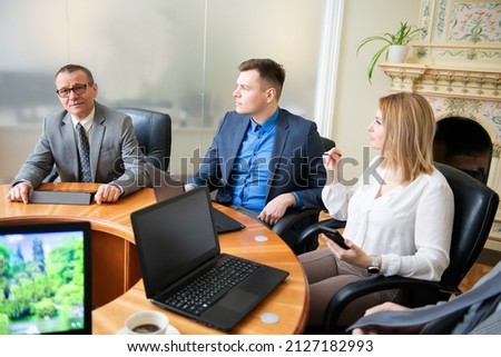A roundtable meeting of business partners , Business people using laptops and tablets 