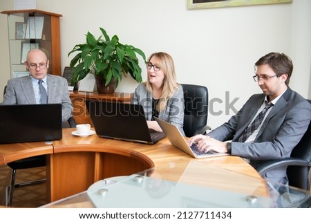 Roundtable meeting of business partners  Business people using laptops and tablets 