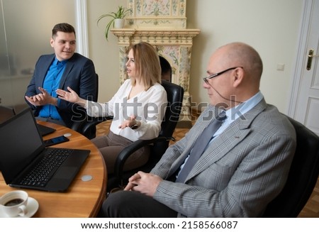 Roundtable meeting of business partners  Business people talking and using laptops and tablets 
