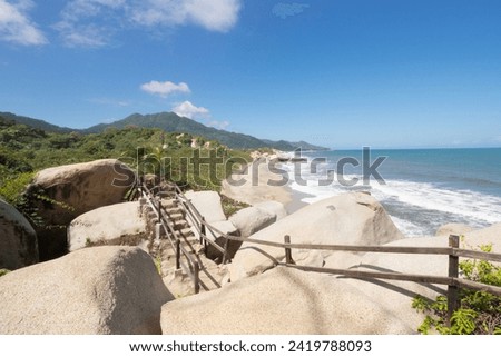 Roustic trekking path stairs with sierra nevada mountain range at background and caribbean sea inside colombian tayrona national park